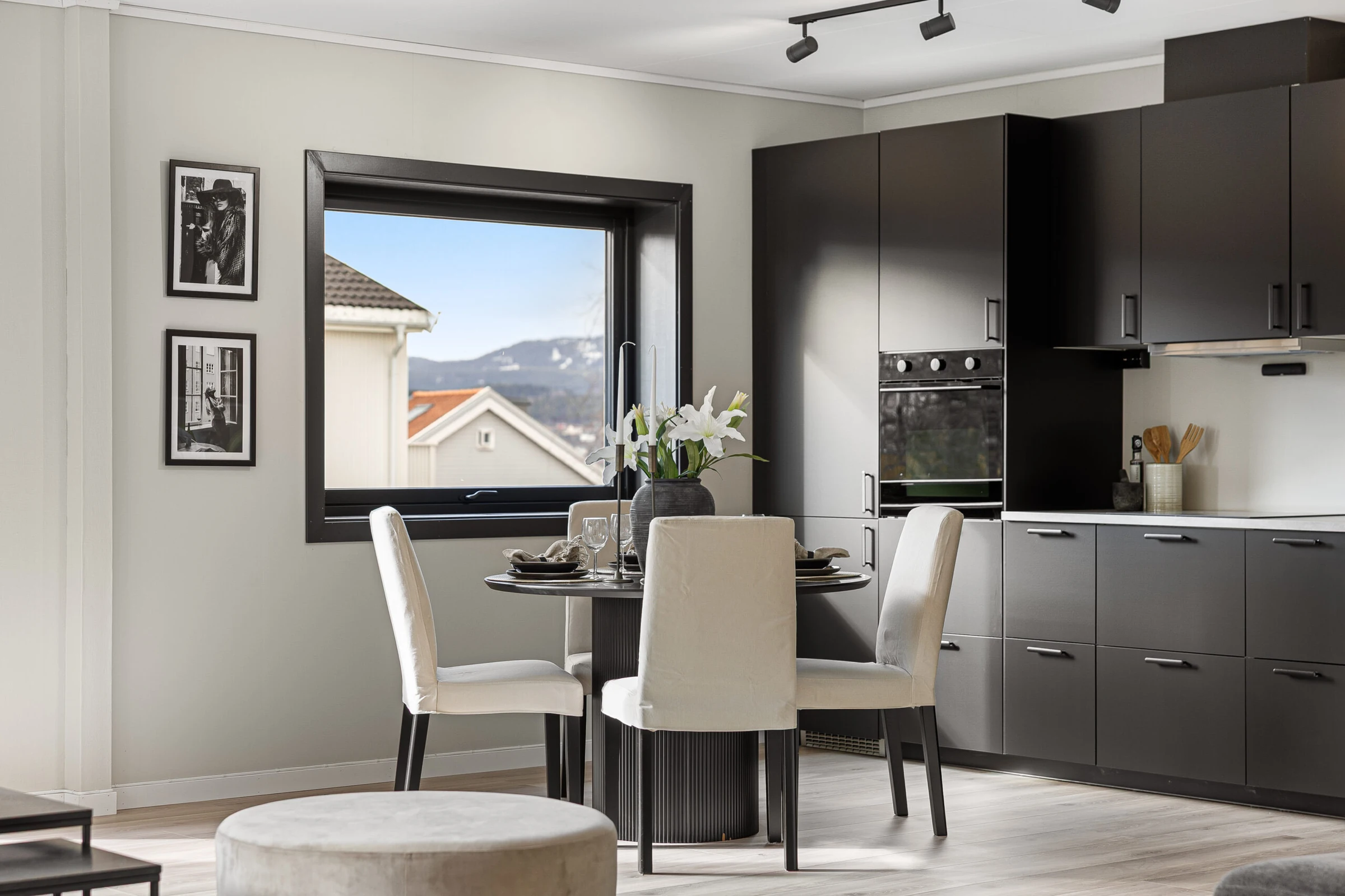 Boligstyling av kjøkken og spiseplass med mørke skap